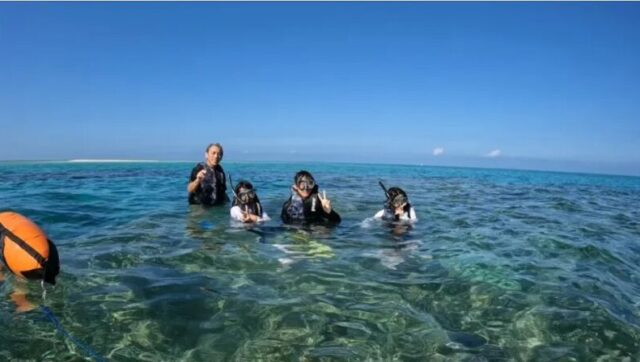 久米島の海のシュノーケリングツアーに参加する家族の笑顔