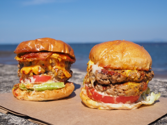 ビーチを背景にしたボリューム満点のハンバーガー