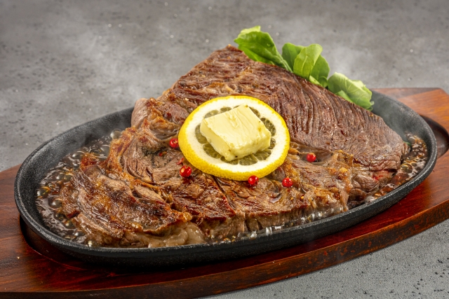鉄板で提供されるステーキとバター