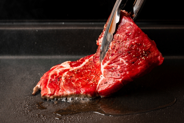 鉄板の上で焼かれる上質な牛肉のステーキ